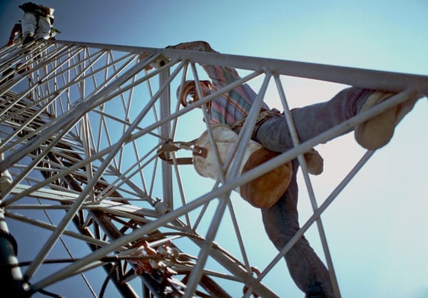 A telecom worker climbing a cell tower.