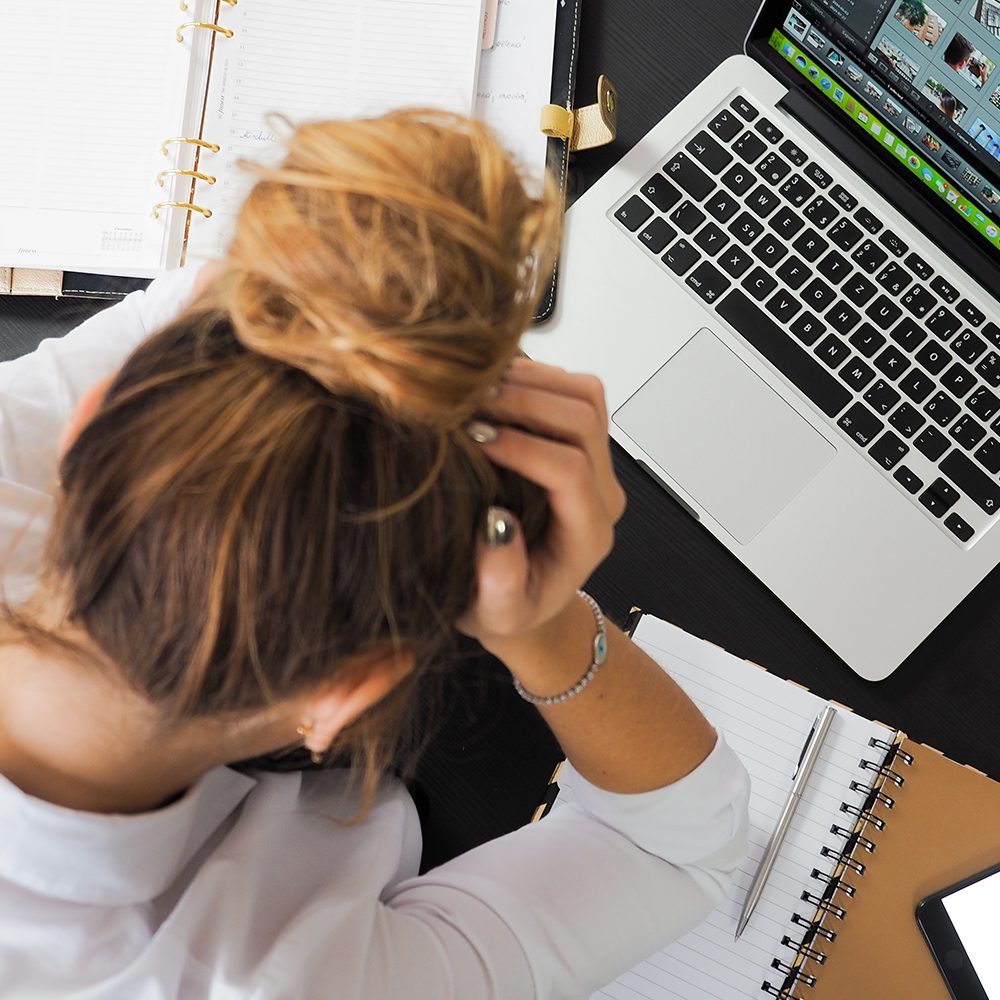 A stressed out woman working on a computer.